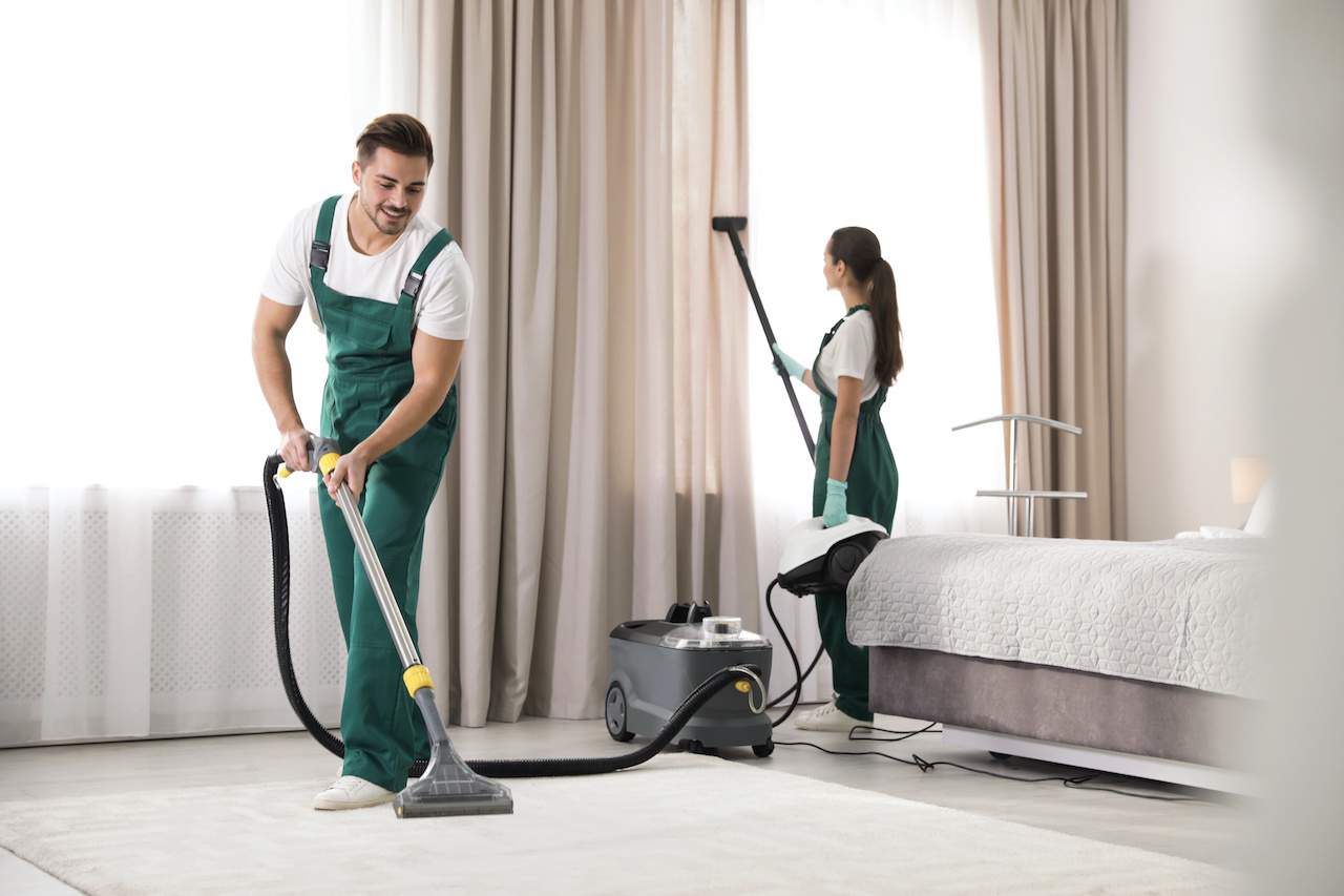 Two carpet cleaning professionals wearing green.