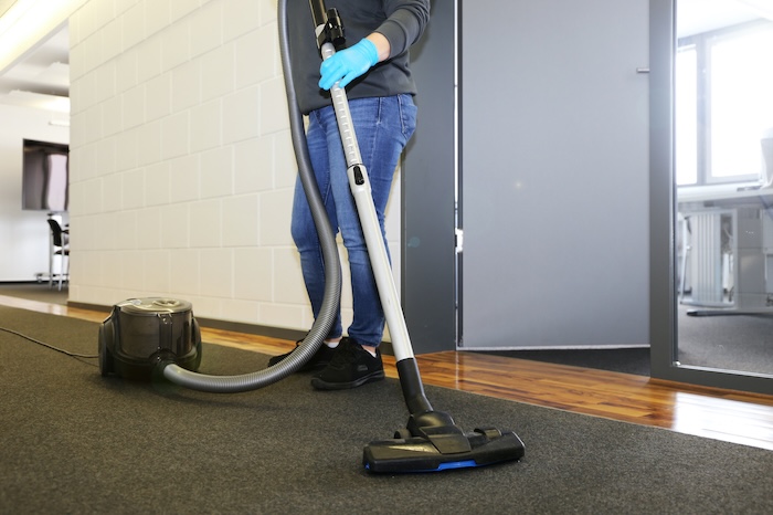 Professional carpet cleaner in an office hallway
